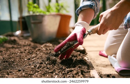 Close Up Of Woman Gardening In Greenhouse Preparing Soil For Planting Seeds - Powered by Shutterstock