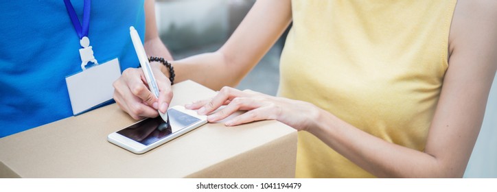 Close up woman hand appending receive sign signature after accepting a delivery of boxes from delivery man, sign and receive deliver e-commerce concept banner