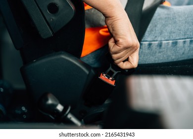 Close up of woman hand buckle the car safety belt. Truck driver occupation 