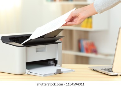 Close Up Of A Woman Hand Catching A Document From A Printer On A Desk At Home