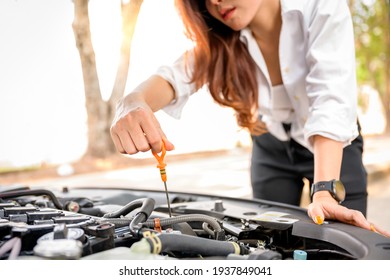 close up of woman hand check engine oil A woman pulls out the dipstick to check the oil level of her car. - Powered by Shutterstock