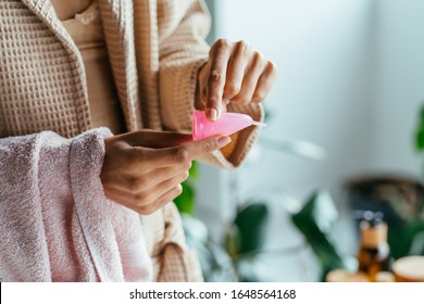 Close up of woman hand folding menstrual cup showing how to use, c form. Women health concept. How to use menstrual cup. Feminine hygiene, eco friendly, zero waste, reuse concept. - Shutterstock ID 1648564168