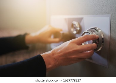 Close up of a woman hand hold and tuning on a combinations safe dial lock - Shutterstock ID 1629779227