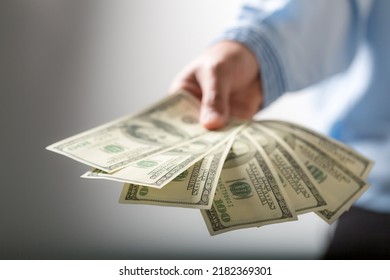 Nahaufnahme einer Hand, die 100 Dollar-Scheine hält. Erfolgreiche Geschäftsfrau mit vielen Geld-Banknote zufrieden. Finanz- und Wirtschaftskonzepte.