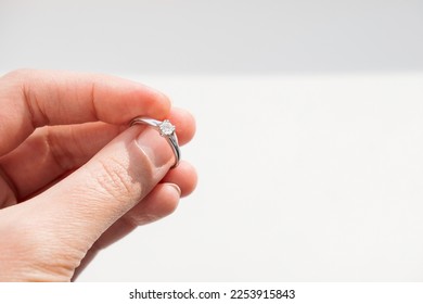 Close up of woman hand holding elegant diamond ring on white background. Diamond engagement brilliant ring. High quality horizontal photo - Powered by Shutterstock