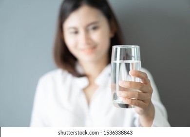 Close up woman hand holding glass of pure water with smile face background, Selective focus - Shutterstock ID 1536338843