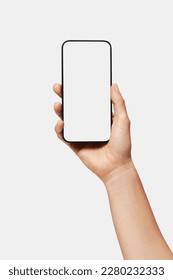 Close up of woman hand holding modern smart phone mockup. New modern black frameless smartphone mockup with blank white screen. Isolated on white background high quality studio shot Modern smart
