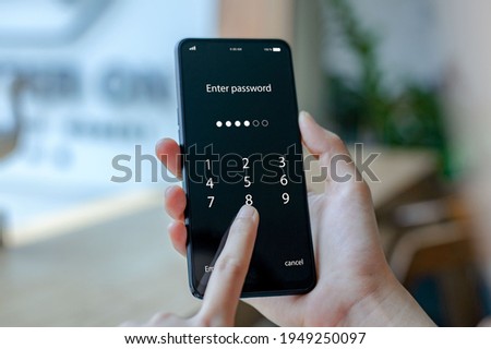 Close up woman hand holding smartphone while entering the passcode. Concept of personal information security
