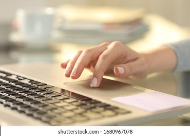 Close up of woman hand with laptop using touchpad on a desk at home