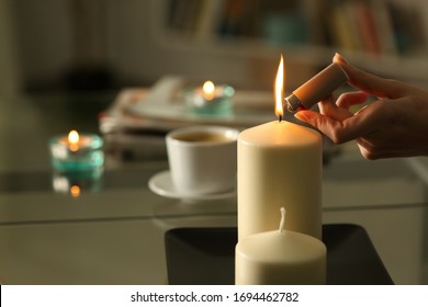 Close Up Of Woman Hand Lighting Candles With Lighter In The Night At Home On A Power Outage