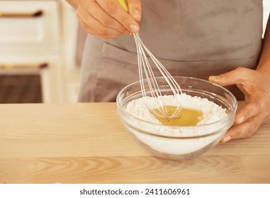 Close up Woman Hand Mixed Batter on Clear Bowl with Baloon Whisk Step by Step Baking Preparation in the Kitchen - Powered by Shutterstock