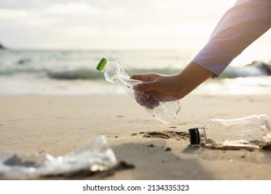 Close up woman hand pick up the plastic bottle on the beach. Female Volunteer clean the trash on the beach make the sea beautiful. World environment day concept. - Powered by Shutterstock