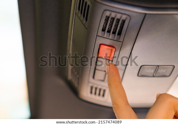 Close up\
woman hand pushes the button SOS in the car.\
