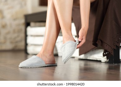 Close up of a woman hand putting slippers in the bedroom - Powered by Shutterstock