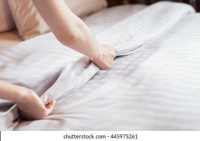 Close Up Woman Hand Set Up White Bed Sheet In Hotel Room