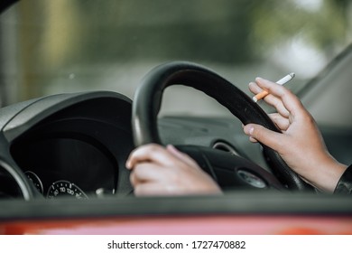 Close Up Of Woman Hand Smoking Cigarette Inside The Car While Driving A Vehicle