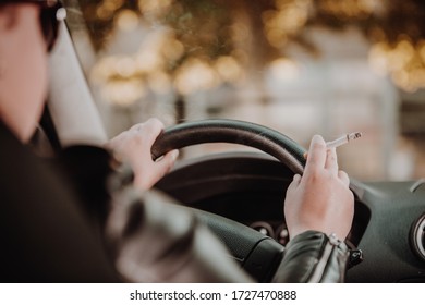 Close Up Of Woman Hand Smoking Cigarette Inside The Car While Driving A Vehicle