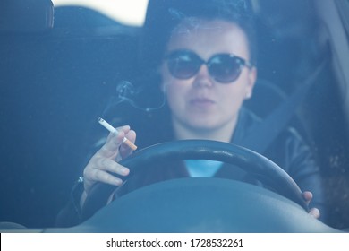 Close Up Of Woman Hand Smoking Cigarette Inside The Car While Driving A Vehicle