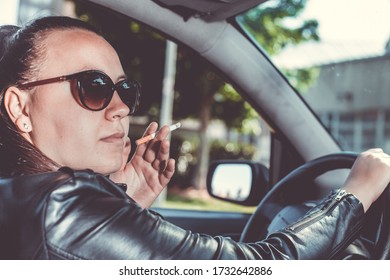 Close Up Of Woman Hand Smoking Cigarette Inside The Car While A Driving Vehicle