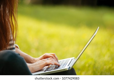 Close Up Woman Hand Typing On Laptop Outside In Park