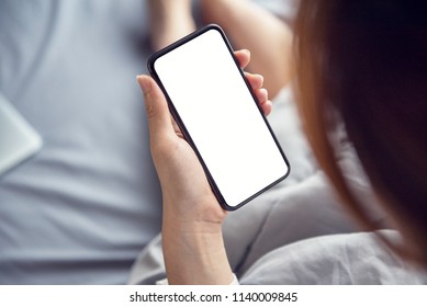 Close Up Woman Hand Using A Smart Phone On Bed At Home.