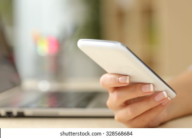 Close Up Of A Woman Hand Using A White Smart Phone On A Desk At Home