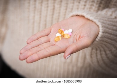 Close Up Of Woman Hand With Vitamins, Minerals And Supplements For Vegans. B12, D3, K2