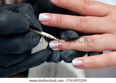 Close up woman hand while process of manicure in nail shop. Beautiful concept.