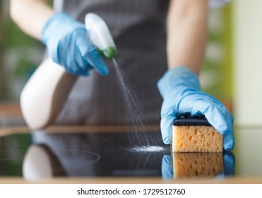 Close Up Of Woman Hands In Blue Protective Rubber Gloves Disinfecting Kitchen Oven With Sponge, Blurred Background