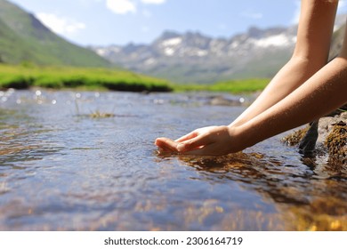 Close up of a woman hands catching water from mountain river - Shutterstock ID 2306164719