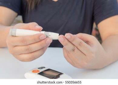 close up of woman hands checking blood sugar level by Glucose meter - Medicine, diabetes, glycemia, health care and people concept - Shutterstock ID 550356655