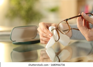 Close Up Of Woman Hands Cleaning Glasses With Tissue Paper On A Desk At Home