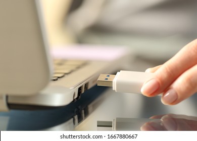 Cerrar las manos de la mujer conectando la unidad USB flash en un equipo portátil