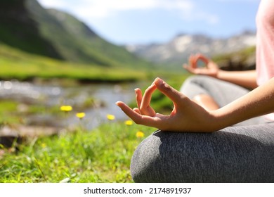 Close up of a woman hands doing yoga in nature beside a mountain river - Shutterstock ID 2174891937