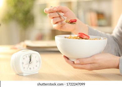 Close Up Of Woman Hands Eating Cereal Bowl With Fruit After Intermittent Fasting Sitting On A Table At Home