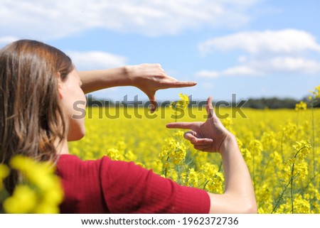 Close up of a woman hands framing flower in a yellow field in spring