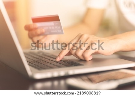 Close up woman hands holding credit card and using laptop shopping purchasing online. e-commerce, internet banking, checking balance, banking service, paying by credit card, making payment