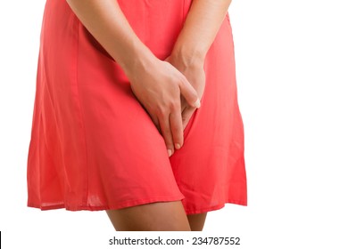 Close up of a woman with hands holding her crotch isolated in white