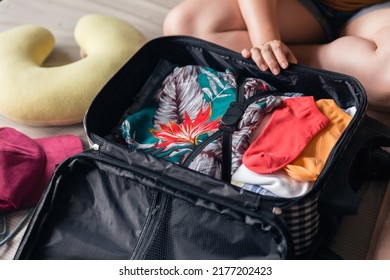 Close Up Woman Hands Holding Mesh Cosmetic Bag And Try To Put Them In Luggage. Packing To Go On A Getaway Vacation.