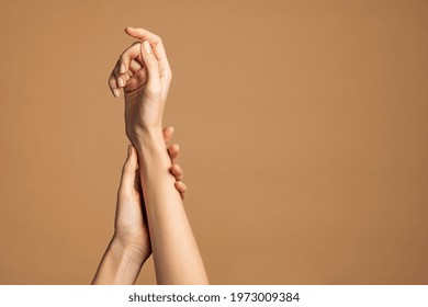 Close up of woman hands isolated on cream brown background with copy space. Smooth female hands applying moisturizer. Beauty gesturing woman's hands with care.