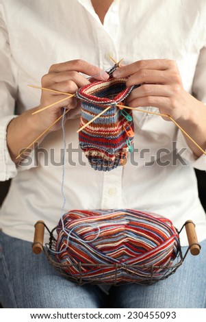 close up of woman hands knitting with knitting needles and yarn ball