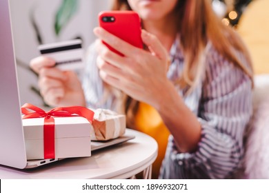 Close Up Of Woman Hands With Mobile Cellphone, Credit Card, Gifts And Laptop. Online Shopping At Christmas, Valentine Day Or Birthday Holidays. Freelance Girl Woking From Home Office