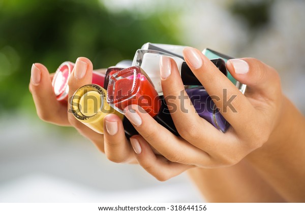 Close up of woman hands with nail polishes of\
different colors