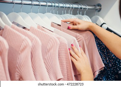  Close Up Woman Hands On Clothes Hangers In A Store Buying Clothes.Shopping.Woman Decides What She Is Going To Try On.