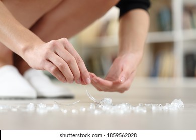 Close Up Of Woman Hands Picking Up Broken Glass On The Floor Avoiding Accident At Home