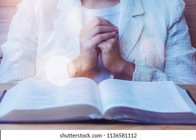 Close Up Of Woman Hands Praying To God While Reading Bible On Wooden Table  In Morning Devotion, Christian 
