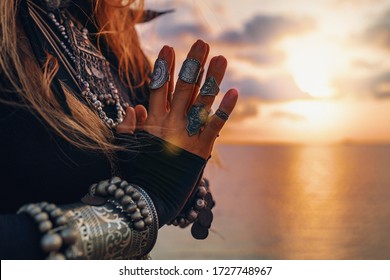 close-up das mãos da mulher. mulher de estilo tribal na praia ao pôr do sol