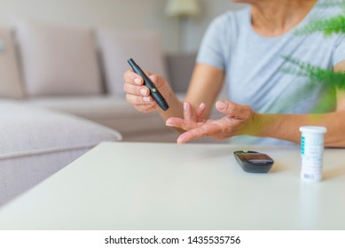 Close Up Of Woman Hands Using Lancet On Finger To Check Blood Sugar Level By Glucose Meter, Healthcare Medical And Check Up, Medicine, Diabetes, Glycemia, Health Care And People Concept