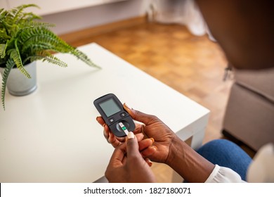 Close Up Of Woman Hands Using Lancet On Finger To Check Blood Sugar Level By Glucose Meter Using As Medicine, Diabetes, Glycemia, Health Care And People Concept.