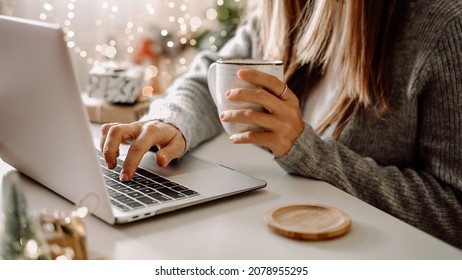 Close Up Of Woman Hands With, Gifts, Coffee Cup And Laptop. Online Shopping At Christmas Holidays. Freelance Girl Woking From Home Office. Female Typing At Notebook Computer. Christmas Moments.